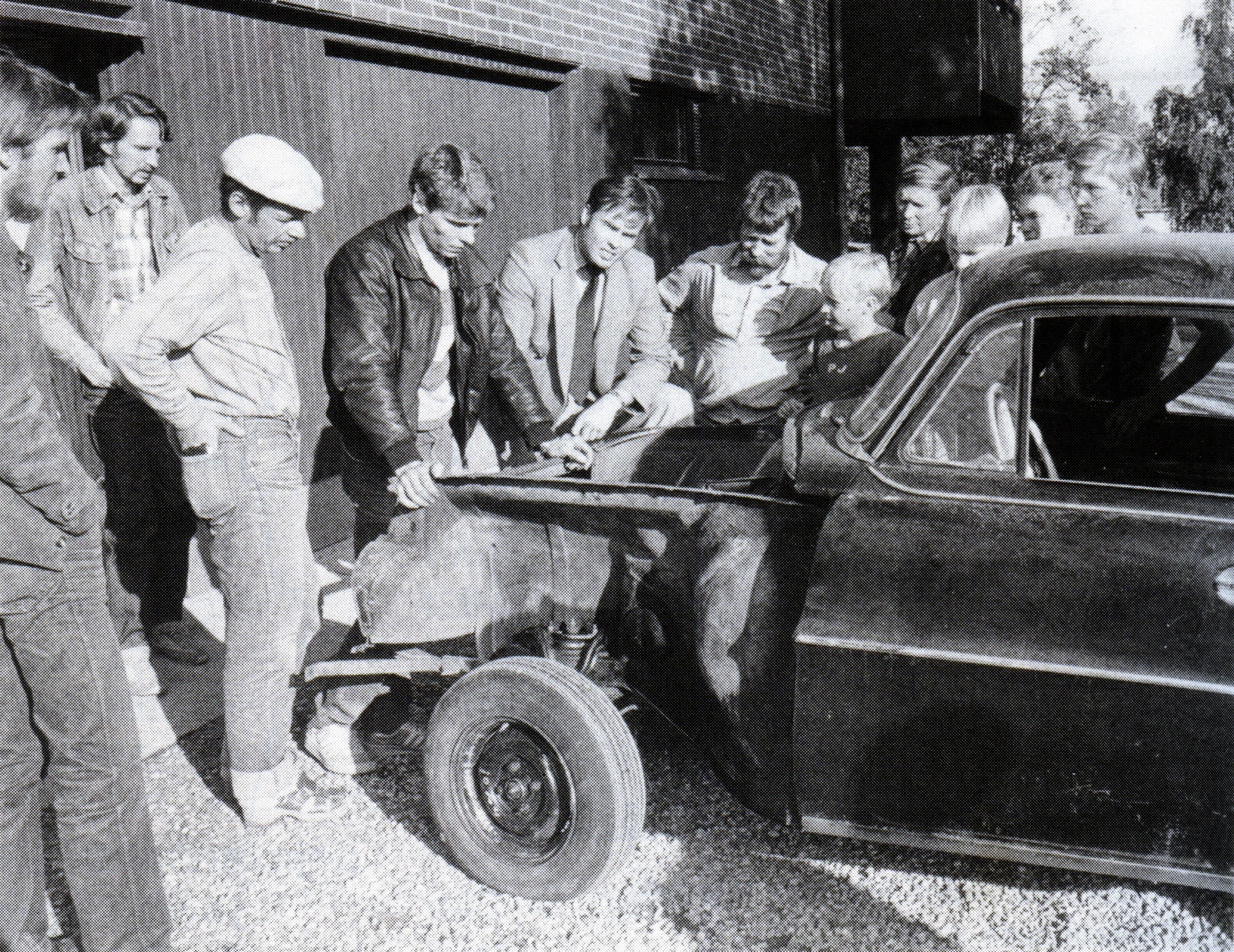 Kerhon perustamiskokouksen osanottajia Opel vm. 1957 ympärillä.  Vasemmalta Jorma Jaakkola, Heikki Jaakkola, Matti Kokkonen, auton omistaja Jukka Pitkänen, Arto Kuukasjärvi, Tapani Juntunen, Pasi Juntunen, Erkki Kuusela, Janne Kannisto, Petri Jeminen, ja Veli-Heikki Malinen.  Kuva otettu 14.8.1982.  Kuva:  Lapin Kansa / Pauli Laalo